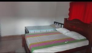 two twin beds in a bedroom with a red curtain at Hospedaje el floral in Tolú