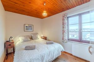 a bedroom with a bed and a large window at La grange du Petit Roure - A 20 km de Saint-Etienne in Grand Roure