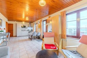 a living room with a kitchen and a dining room at La grange du Petit Roure - A 20 km de Saint-Etienne in Grand Roure