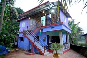 een blauw huis met een trap ervoor bij Happy Homestay in Māvalli