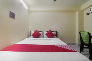 Un dormitorio con una cama grande con almohadas rojas. en Hotel O by OYO Shyam Guest House, en Kharagpur