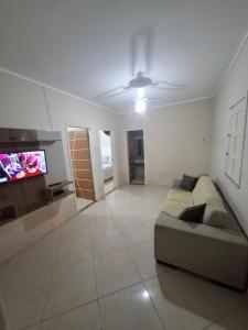 ein Wohnzimmer mit Sofa und Flachbildfernseher in der Unterkunft Chalé das Palmeiras in Itabaiana