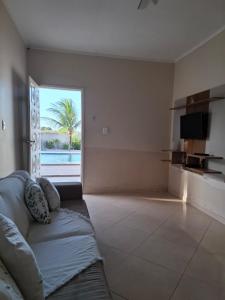 ein Wohnzimmer mit Couch und großem Fenster in der Unterkunft Chalé das Palmeiras in Itabaiana