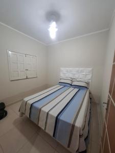 ein Schlafzimmer mit einem Bett in einem weißen Raum in der Unterkunft Chalé das Palmeiras in Itabaiana + 4 Fotos