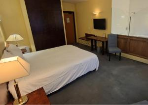 a hotel room with a large bed and a desk at Hôtel Terminus in Cahors +17 photos