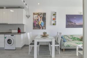 a kitchen and dining room with a table and a couch at Atico de Lux Zahara in Zahara de los Atunes