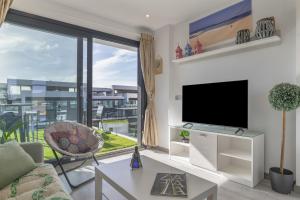 a living room with a tv and a large window at Atico de Lux Zahara in Zahara de los Atunes