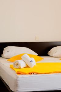 a bed with towels and pillows on it at London Rooms Zagreb Airport in Velika Gorica