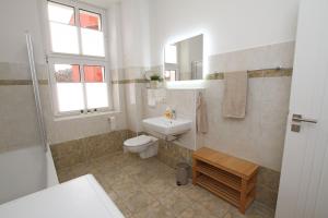 a bathroom with a toilet and a sink and a mirror at Gästewohnung "ZeitRaum" in Halberstadt