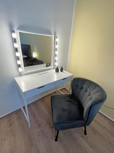a desk and a chair in a room with a mirror at Gästewohnung "ZeitRaum" in Halberstadt