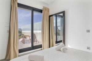 a bedroom with a bed and a large window at Atico de Lux Zahara in Zahara de los Atunes +25 photos