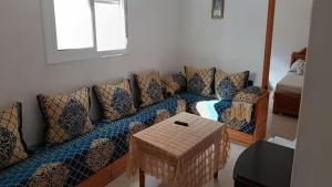 ein Wohnzimmer mit Sofa und Tisch in der Unterkunft Petit appartement à martil in Martil