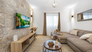 a living room with a couch and a stone wall at Holiday house Hedonica by Villas Guide in Mirlović Zagora