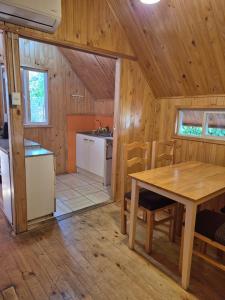 a kitchen and dining room with a table in a cabin at Carolin Cacao - Cabaña Nogal in San José de Maipo +9 photos