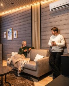 a man and a woman sitting on a couch at Lapland Winter Park Chalets in Rovaniemi