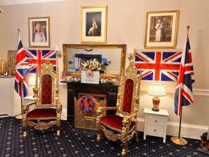 a room with two chairs and a fireplace with british flags at Jubilee Hotel Victoria in London