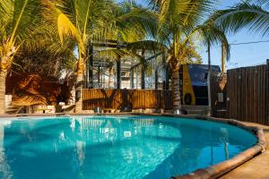 a large swimming pool with palm trees in the background at Palm Valley Cabins in Mazatlán