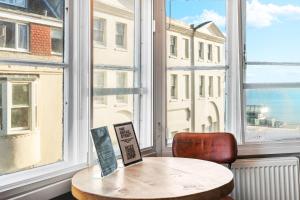 a table and a chair in a room with a window at One Broad Street in Brighton & Hove