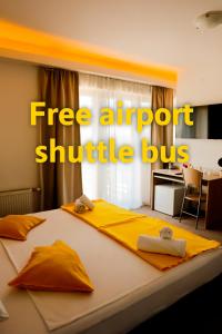 a bedroom with a bed with the words free airport shuttlebus at London Rooms Zagreb Airport in Velika Gorica