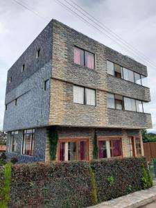 Un gran edificio de ladrillo con fachada de piedra. en Hotel Bethel, en Tababela