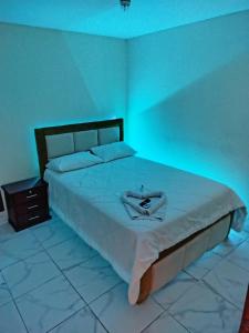 1 dormitorio con 1 cama blanca grande con luces azules en Hotel Bethel, en Tababela