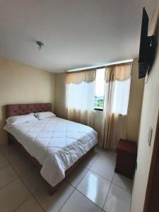 Un dormitorio con una cama y una ventana grande. en Hotel Bethel, en Tababela