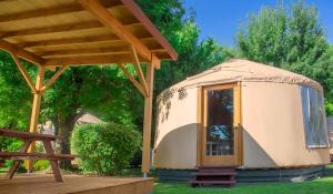 una yurta en un patio con una plataforma de madera en Camping Le Beauvillage, en Lauzerte