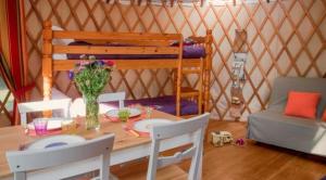 Una habitación con una mesa y una cama en una yurta en Camping Le Beauvillage, en Lauzerte