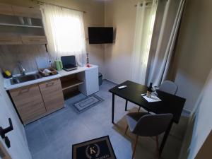 a small kitchen with a desk and a table with chairs at knezevic resorts 14 in Mesochórion
