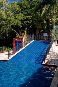 una piscina con valla y agua azul en Pousada do Rio Turvo, en Capitólio 95 fotos más