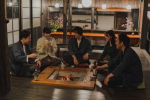 een groep mensen die rond een vuurkorf zitten bij Kamogawa919 in Kamogawa