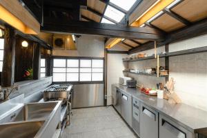een grote keuken met een wastafel en een fornuis bij Kamogawa919 in Kamogawa
