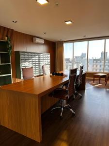 an office with a large wooden table and chairs at Studio New York in Imbituba +17 photos