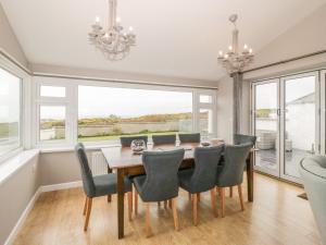 a dining room with a table and chairs and a window at Dunholme in Holyhead