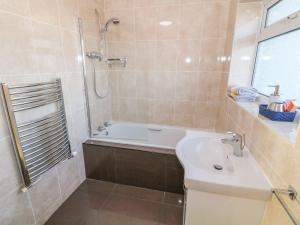 a bathroom with a tub and a sink and a shower at Dunholme in Holyhead +19 photos