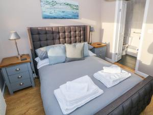 a bedroom with a large bed with towels on it at Dunholme in Holyhead