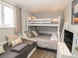 a room with two bunk beds and a couch at Dunholme in Holyhead