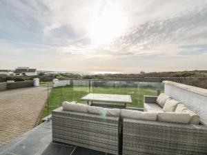 a patio with a couch and a table on a roof at Dunholme in Holyhead