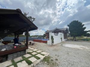 a man sitting at a table in front of a building at FMAZ Cottage in Kampong Gong
