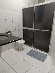 um banheiro com chuveiro, vaso sanitário e pia em Hotel Internacional em Cianorte