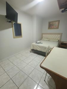 um quarto com uma cama e piso em azulejo em Hotel Internacional em Cianorte mais 22 fotografias