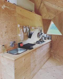 een keuken met een gootsteen in een houten kamer bij Prêt-à-camper, dôme in La Tuque +15 foto's