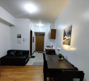 a living room with a black couch and a table at 8Adriatico Condo near US Embassy in Manila