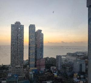 a view of a city with tall buildings and the ocean at 8Adriatico Condo near US Embassy in Manila