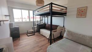 Cosy Mélodie - T3 - Parc Expo - Balcon & Parking collectif gratuit في بو: غرفة نوم مع سرير بطابقين وأريكة