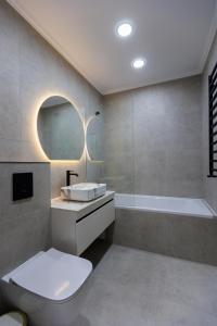 a bathroom with a toilet and a sink and a tub at Luna Minimalist Apartment in Chişinău