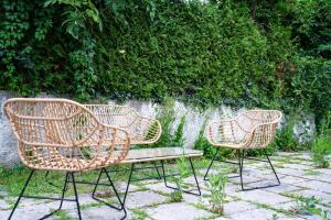 two wicker chairs and a bench in front of a wall at Studio D'or in Grenchen +26 photos
