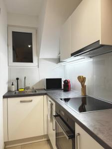a kitchen with white cabinets and a sink at Studio D'or in Grenchen