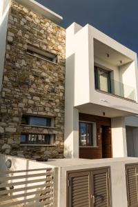 Hubstay - Seaview Villa Oriana in Larnaca في لارنكا: منزل حديث مع جدار حجري +44 صورة