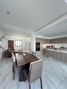 Hubstay - Seaview Villa Oriana in Larnaca في لارنكا: مطبخ وغرفة معيشة مع طاولة وكراسي خشبية